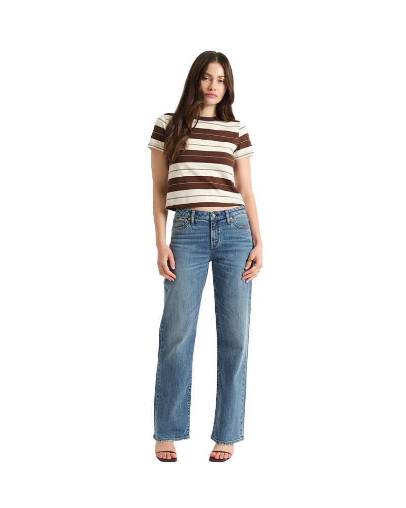 Woman wearing a striped shirt and jeans on a white background