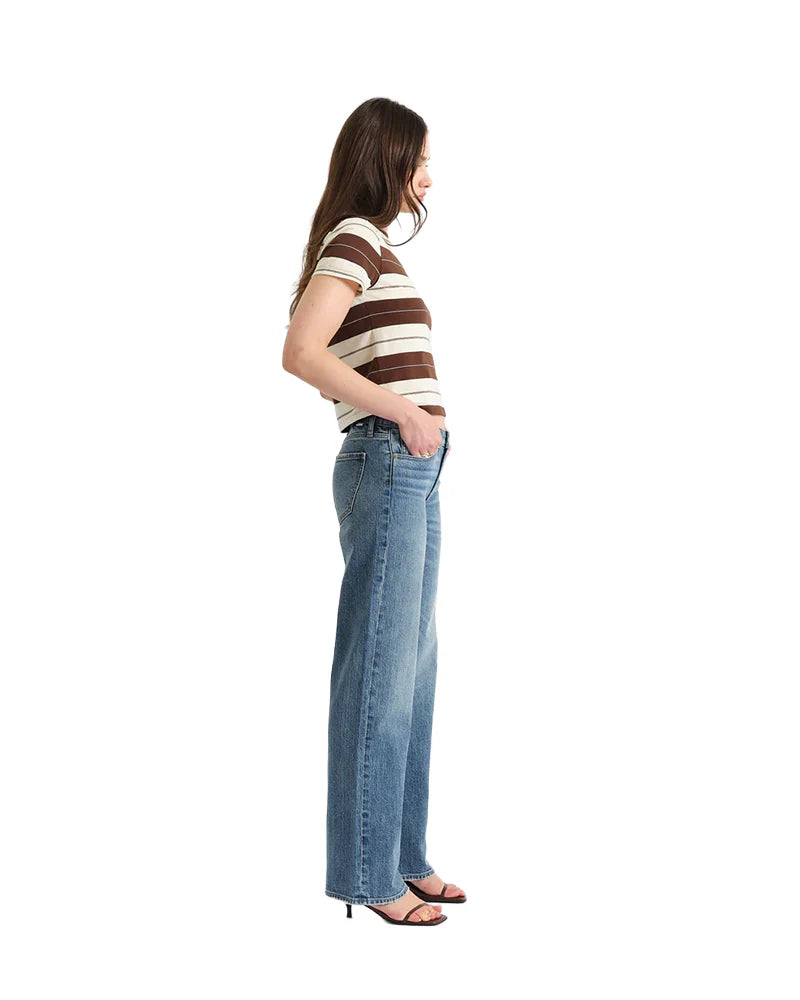 Woman wearing a striped shirt and jeans on a white background