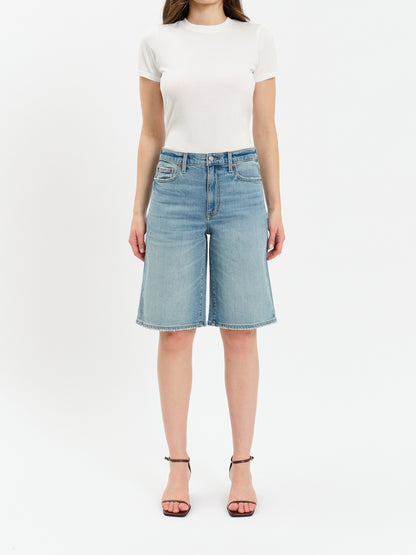 Person wearing a white t-shirt and light blue denim shorts on a white background