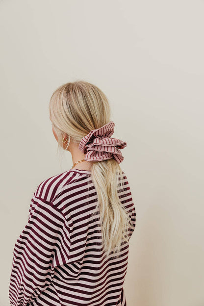 Pink and maroon striped scrunchie styled in hair